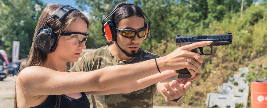 Woman shooting gun at range