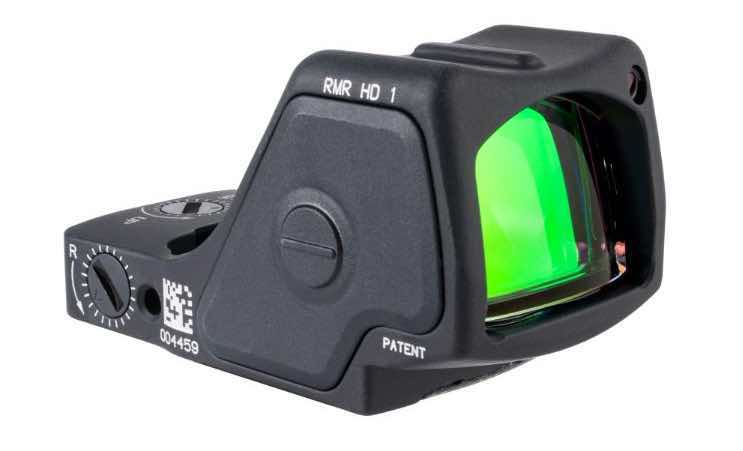 Close-up of a black reflex sight with a green lens.