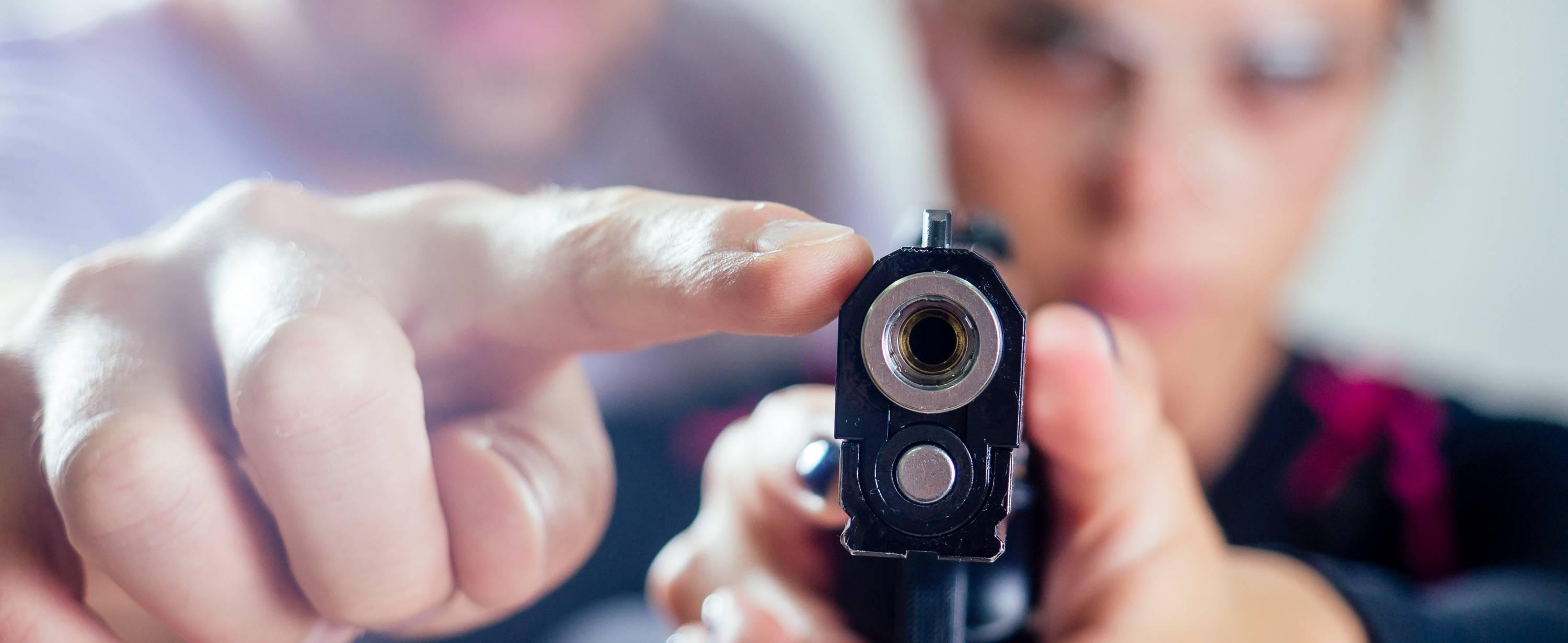 Woman being trained on shooting a handgun