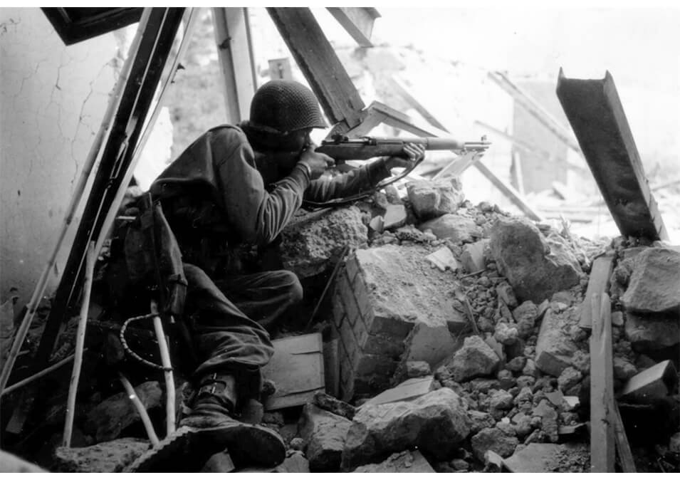Soldier laying in rubble with a M1 Garand