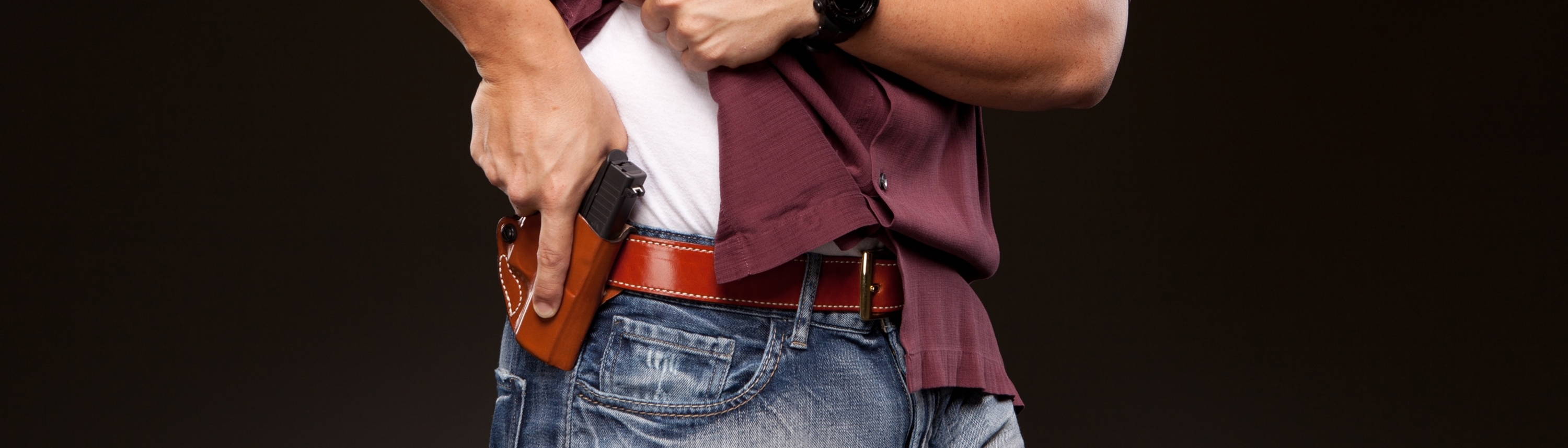 Man pulling handgun from holster