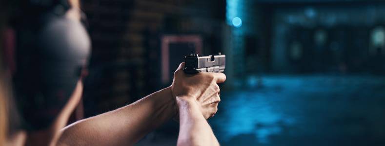 Man practicing shooting at indoor shooting range