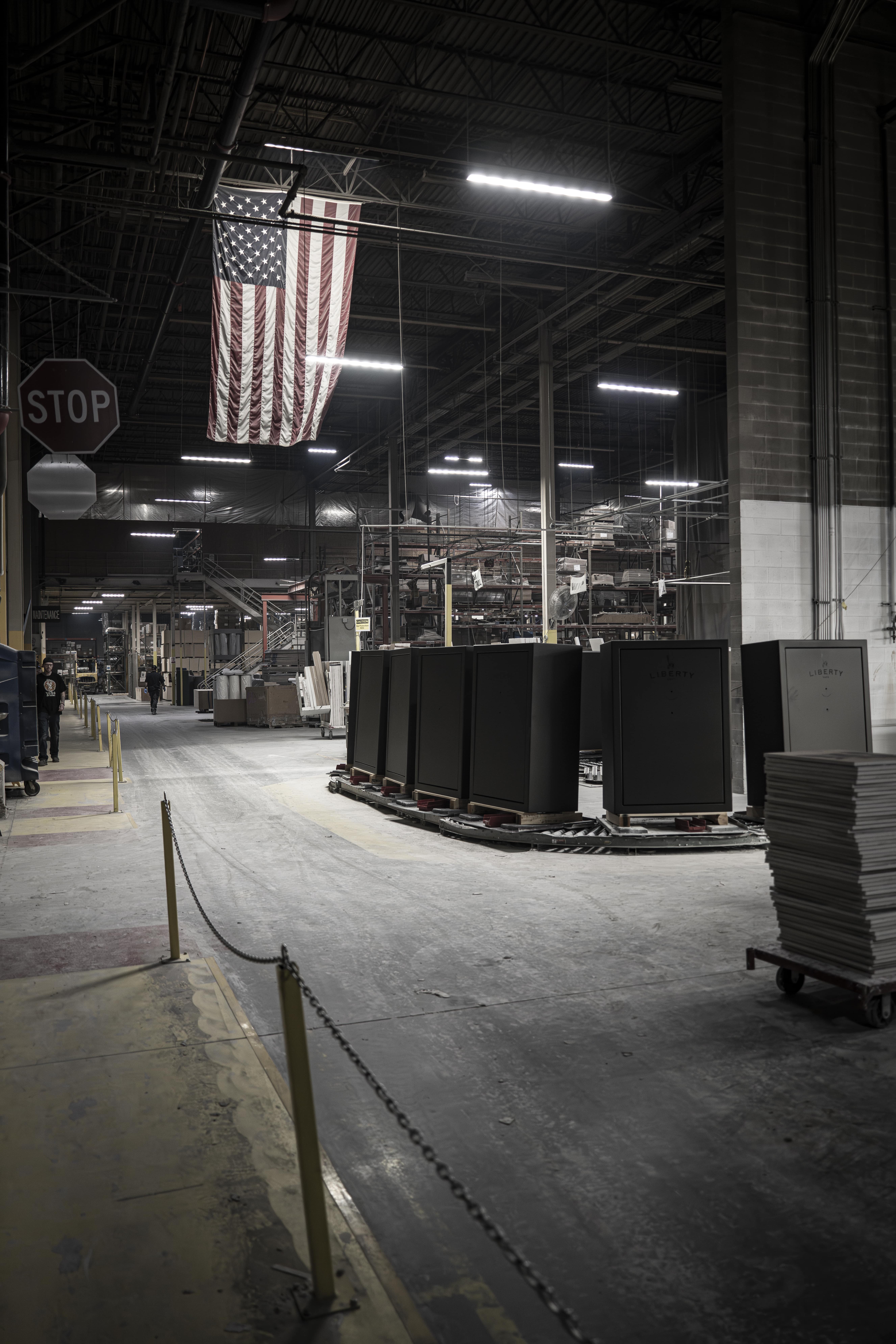 Warehouse interior with American flag and stacked materials.