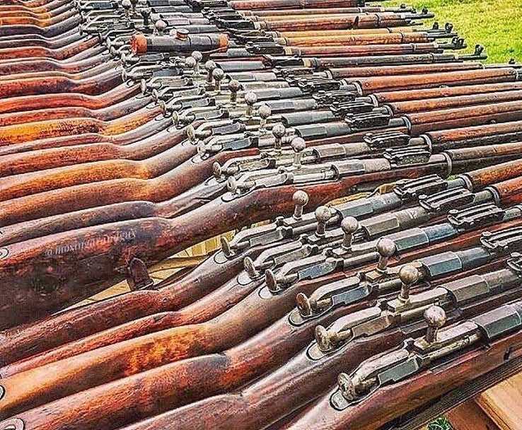 A row of vintage rifles displayed on a surface.