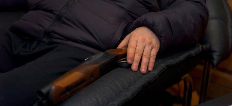 Man Sitting on Chair With Home Defense Shotgun