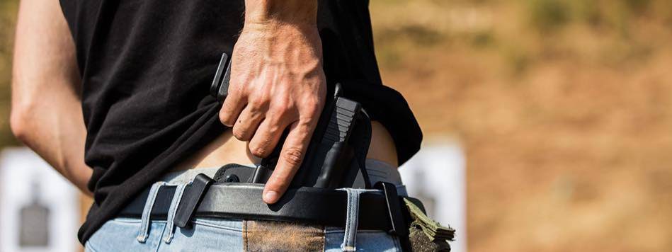Man pulling out concealed carry handgun