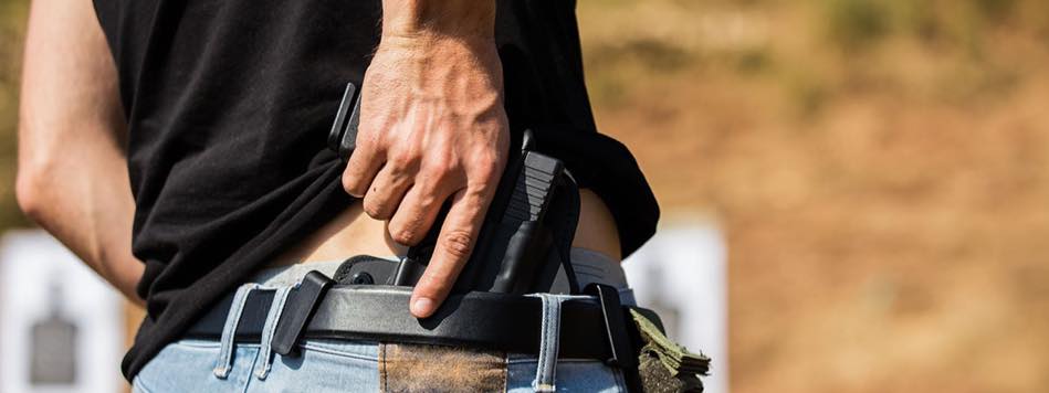 Man pulling out concealed carry handgun