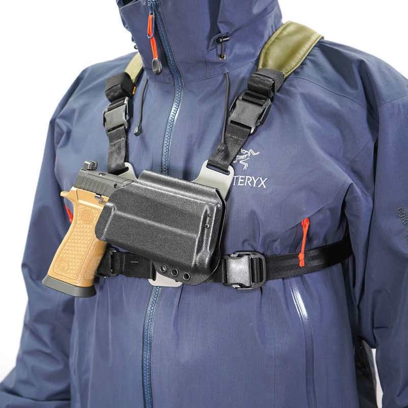 Person wearing a blue jacket with a firearm in a shoulder holster.