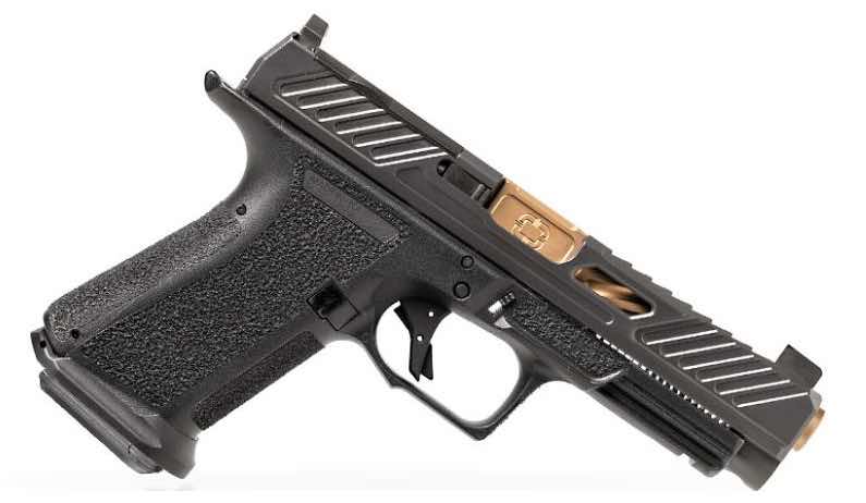 A black semi-automatic Shadow Systems MR920L handgun with a textured grip and gold accents.