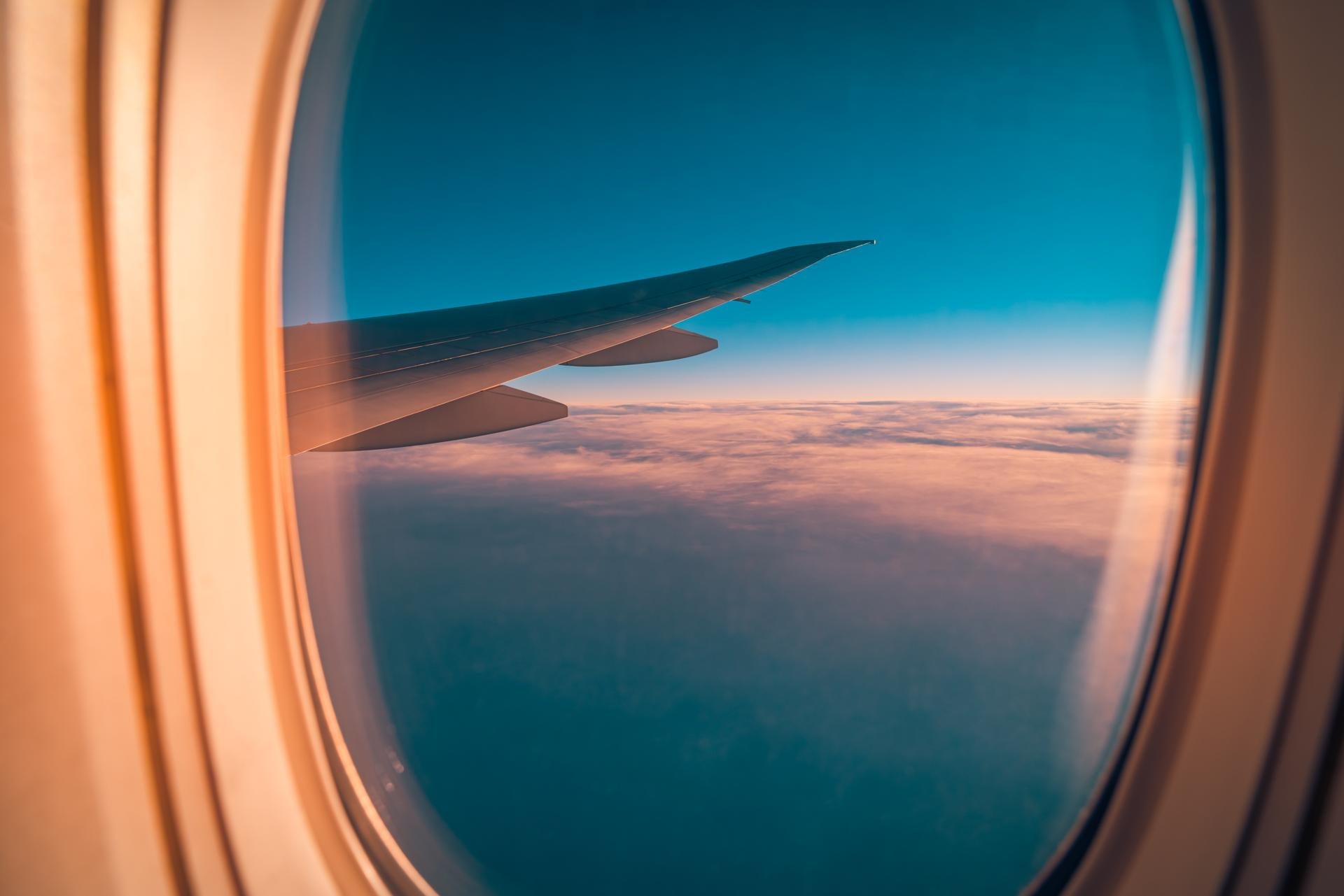 Sunset sky with fluffy clouds seen from airplane window, inspiring peaceful travel moments, vacation adventure, and modern transportation in beautiful aerial scenery