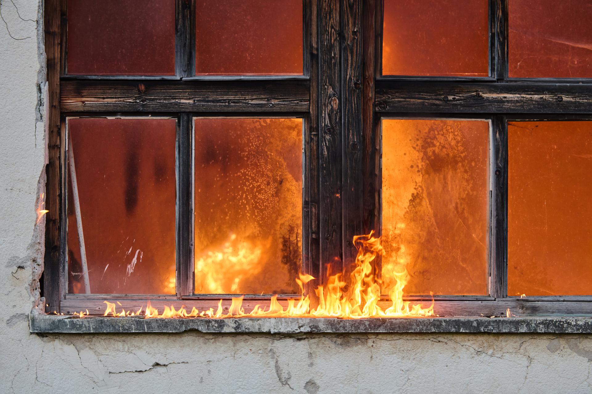 Window engulfed in flames, burning building, fire damage, burning house, danger concept, fire safety, destruction, emergency situation, fire accident, disaster scene