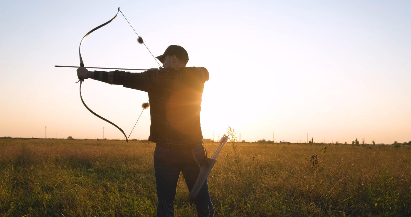Man with bow outdoors in the field