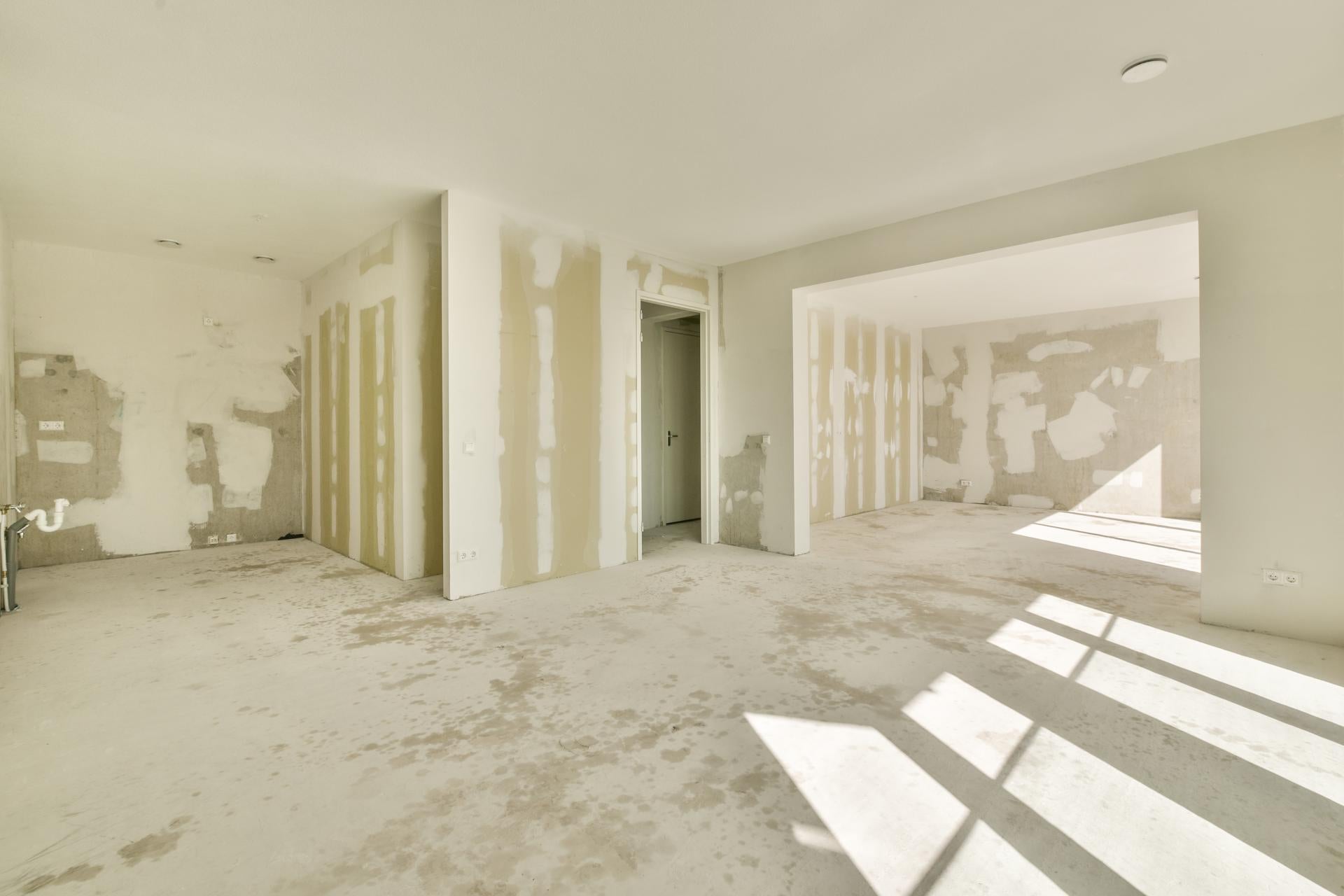 An empty room with drywall and paint on the walls