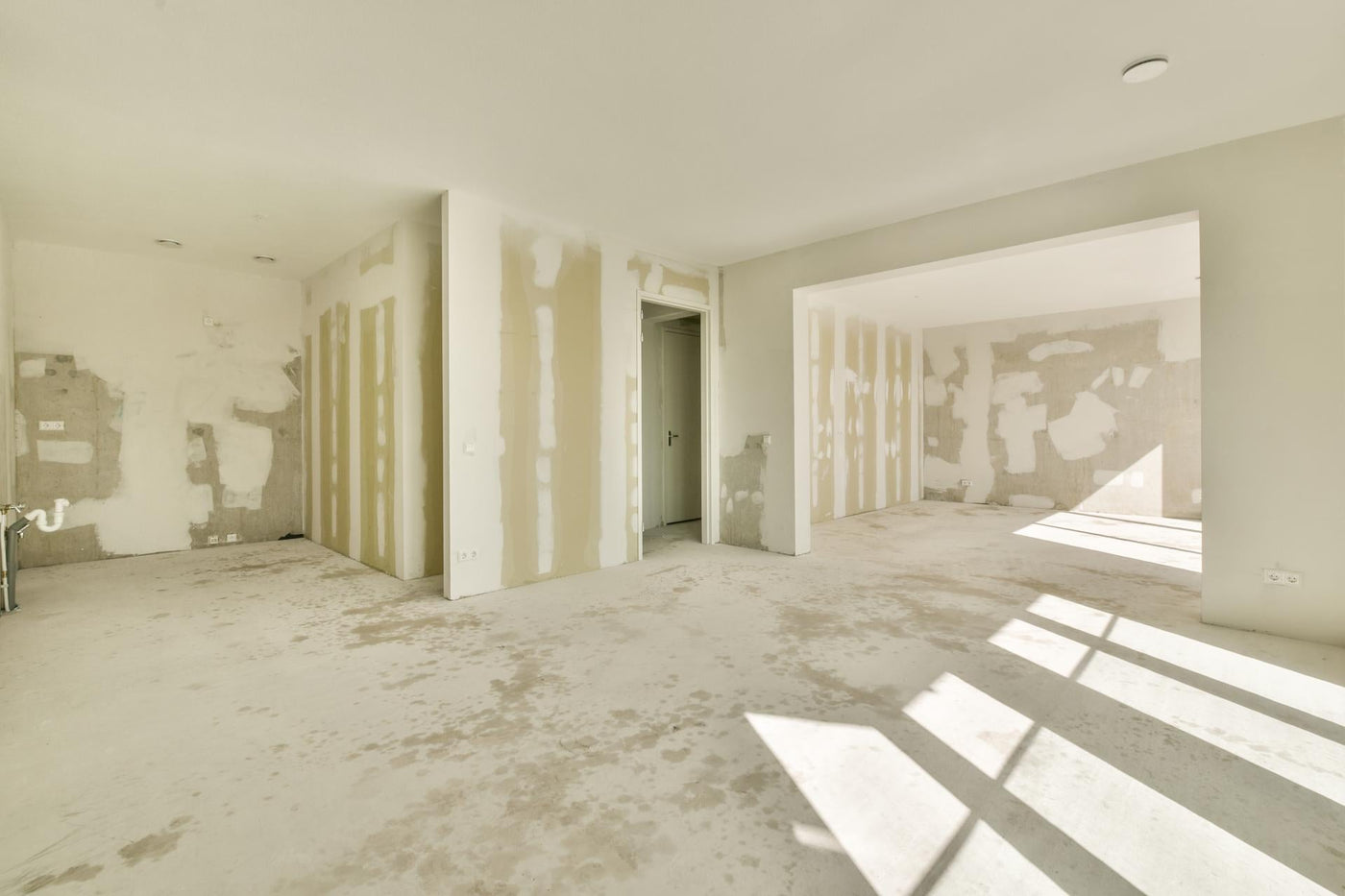 An empty room with drywall and paint on the walls