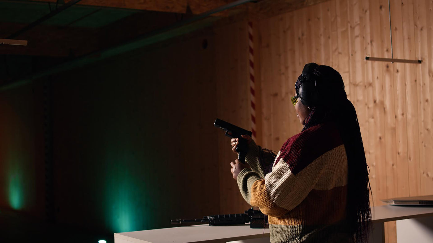 Cheerful woman in shooting range trying out new gun model before committing to purchase. Happy person in shooting range learning how to operate new weapon safely during self defense training, camera A