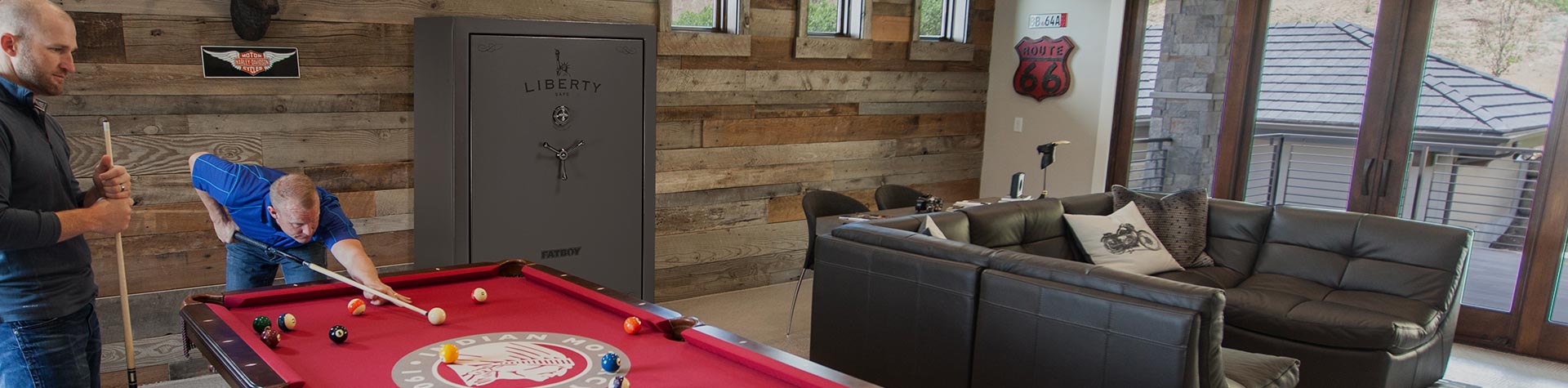 Two men playing pool in front of Liberty Fatboy gun safe