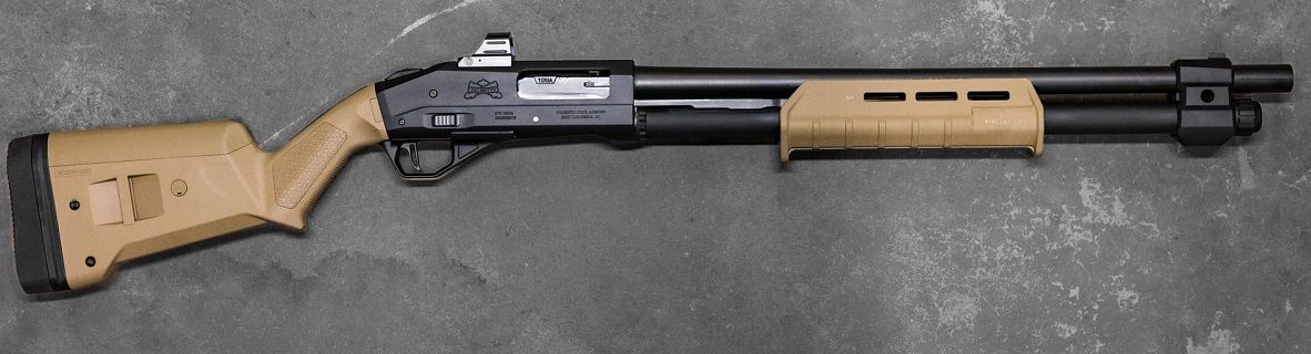 A black and tan shotgun on a gray surface.