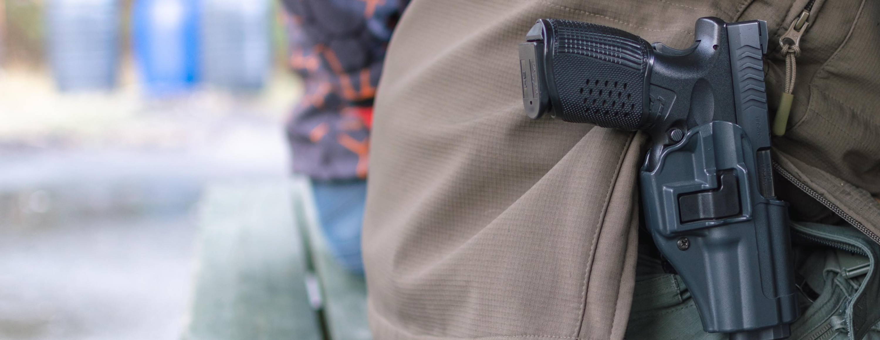 Man sitting on park bench with firearm in holster