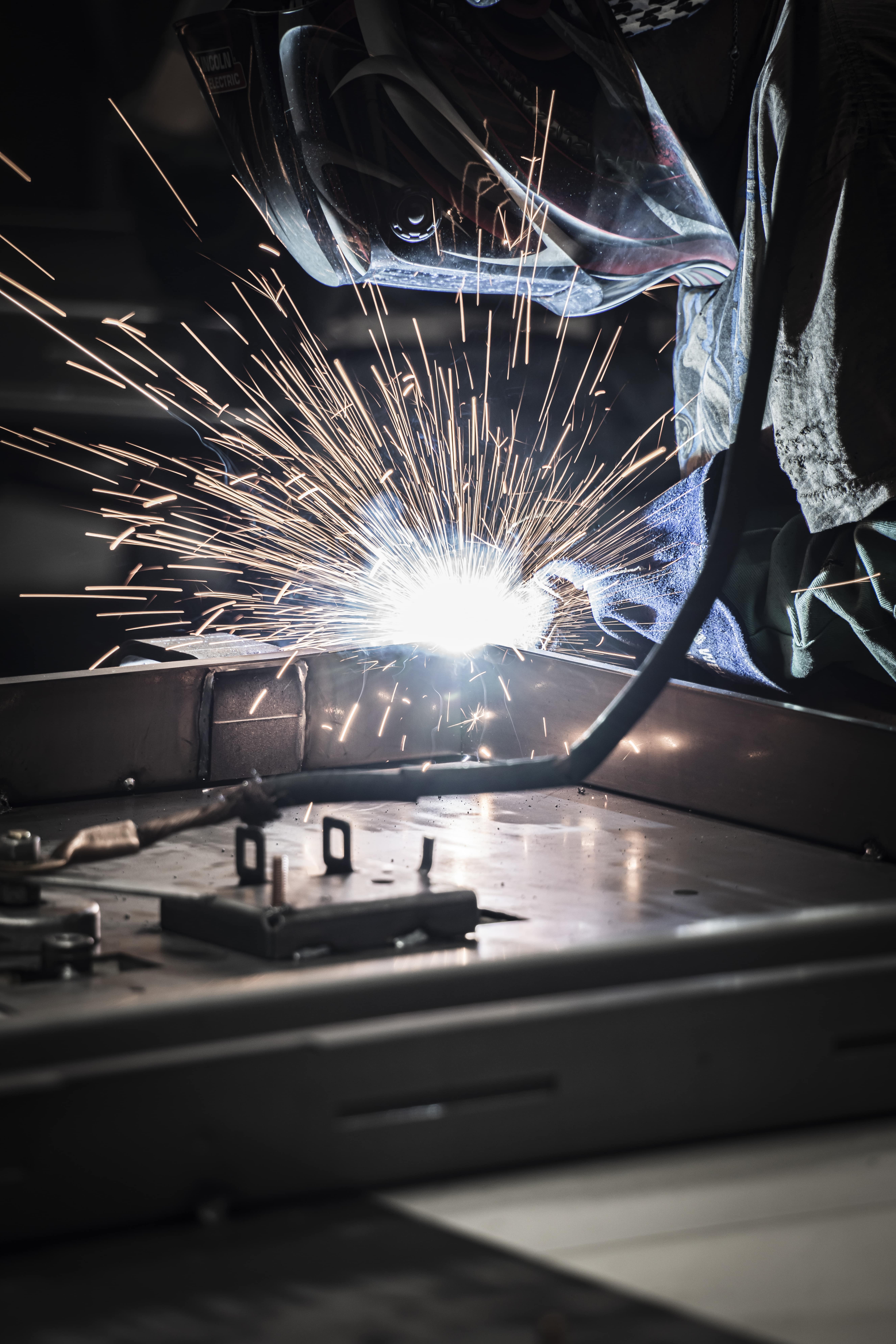 Welding sparks flying in a workshop environment.