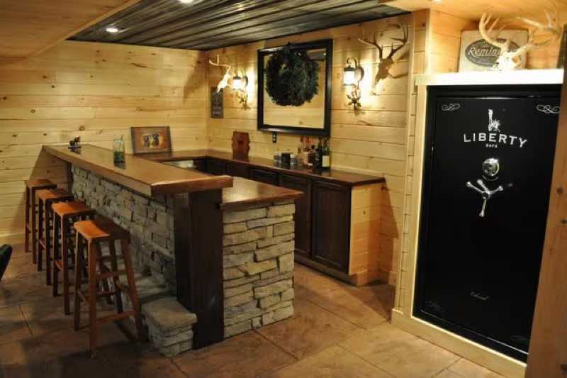 A rustic bar area with stone accents and a black safe.